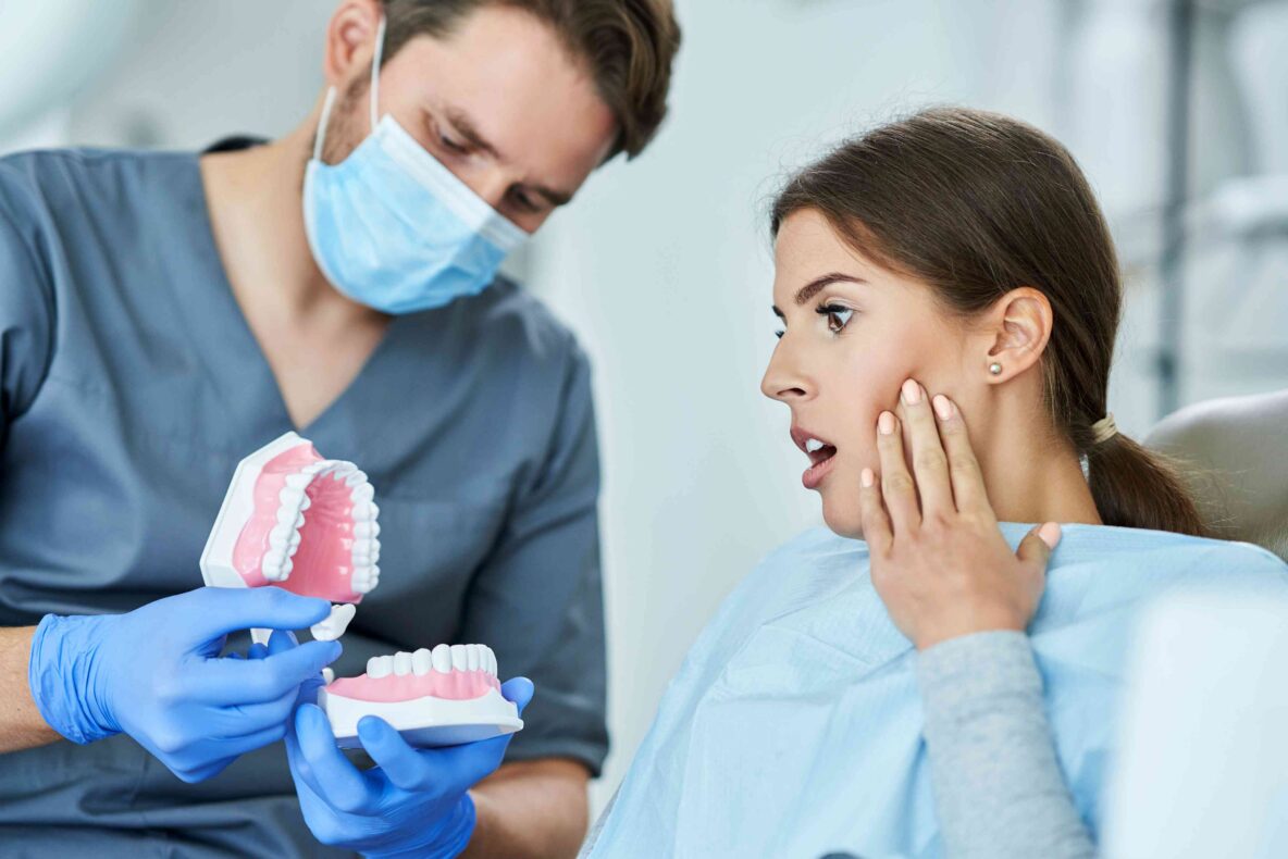 Patient holding her jaw during a dental consultation.