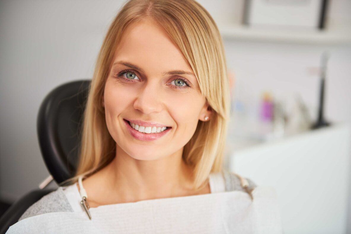 Smiling woman seated in a dental chair.